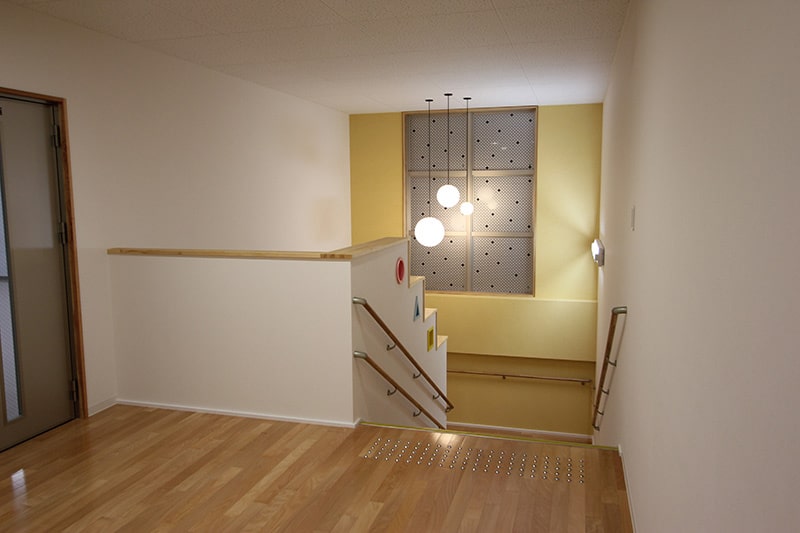 廊下突き当たりの下階に降る階段の写真